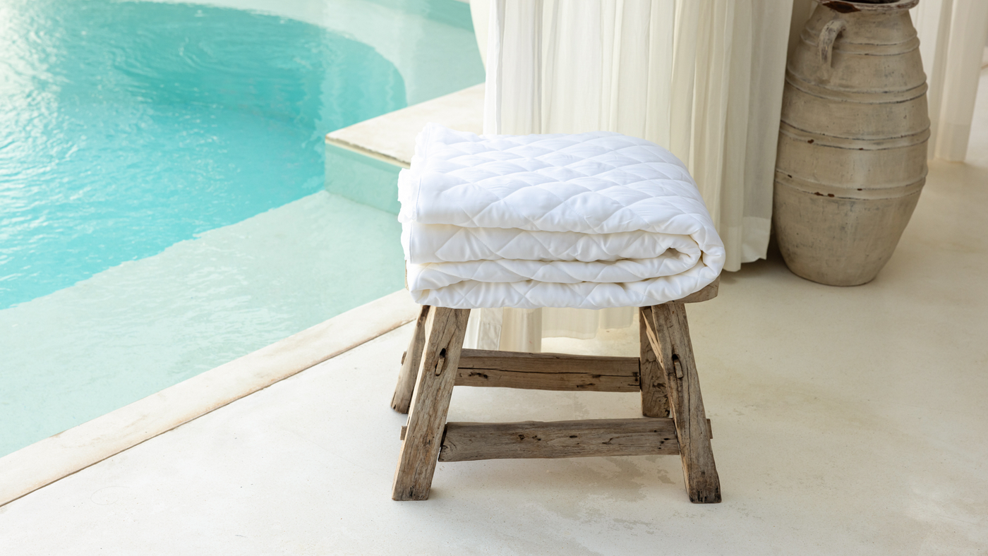 an image of aeptom mattress pad protector next to a beautiful pool